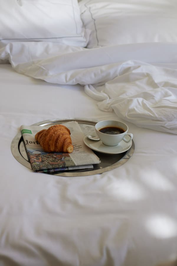 photographie matin café croissant hotel chambre couette blanche