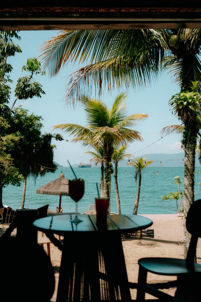 Table et verre en terrasse face à la mer et aux palmiers, Club Med Rio das Pedras, Brésil