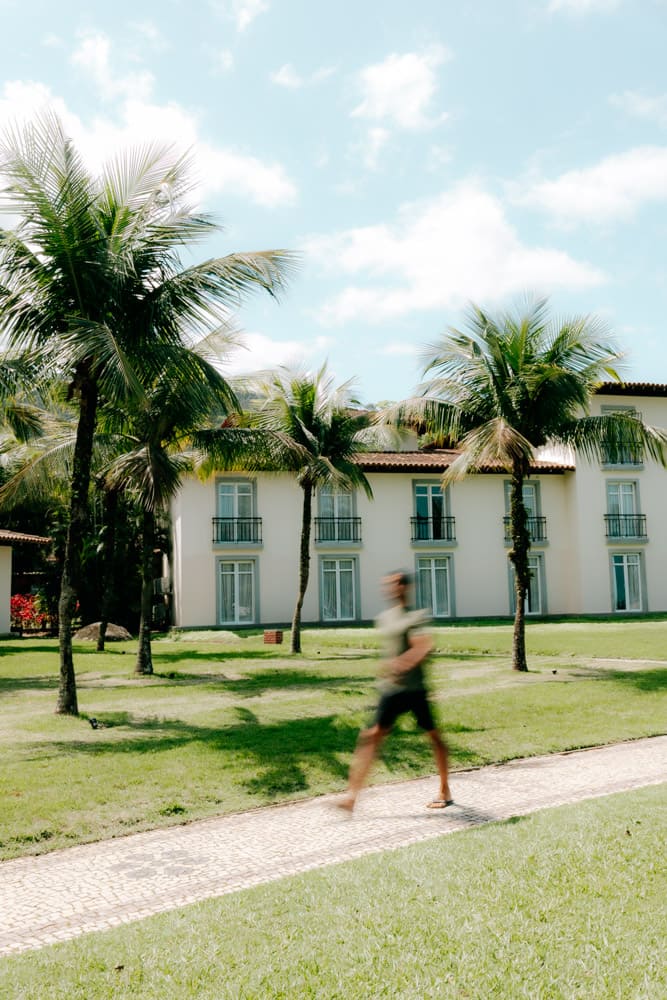 Bâtiment blanc de l'hôtel entre palmiers et pelouse, resort Club Med Rio das Pedras au Brésil