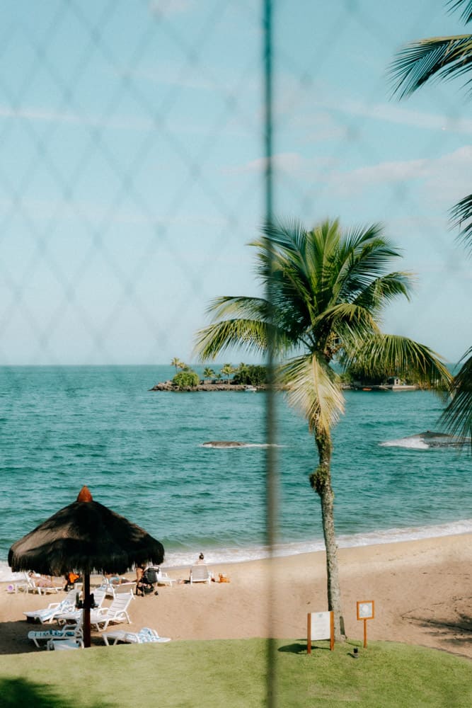 Paillote et palmier sur la plage vus à travers un filet, Club Med Rio das Pedras sur la Costa Verde