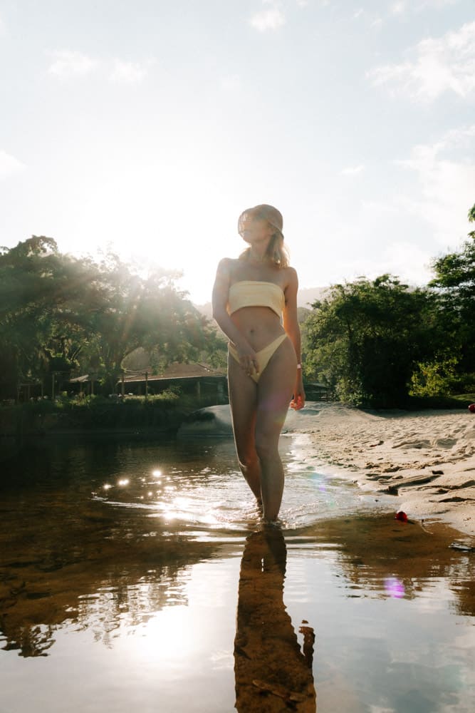 Femme en maillot clair dans la rivière en contre-jour au soleil couchant, photographie travel au Brésil
